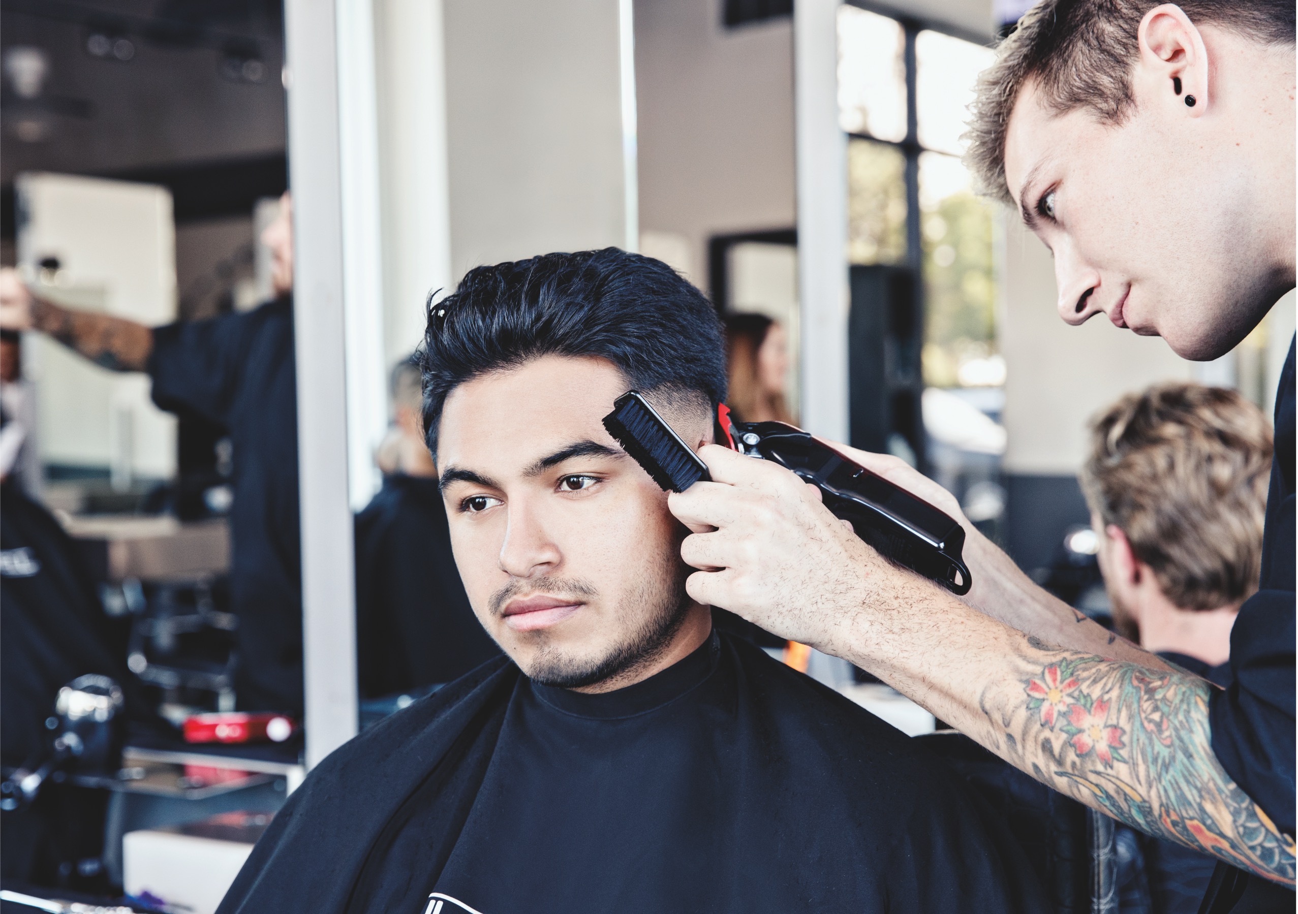 barber school student trimming and styling guest's hair