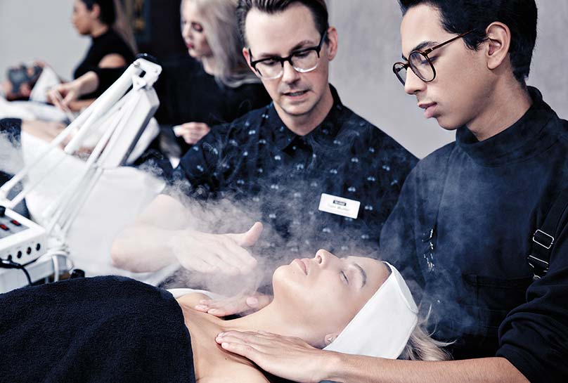 student and teacher reviewing a skin techniques on a guest laying down