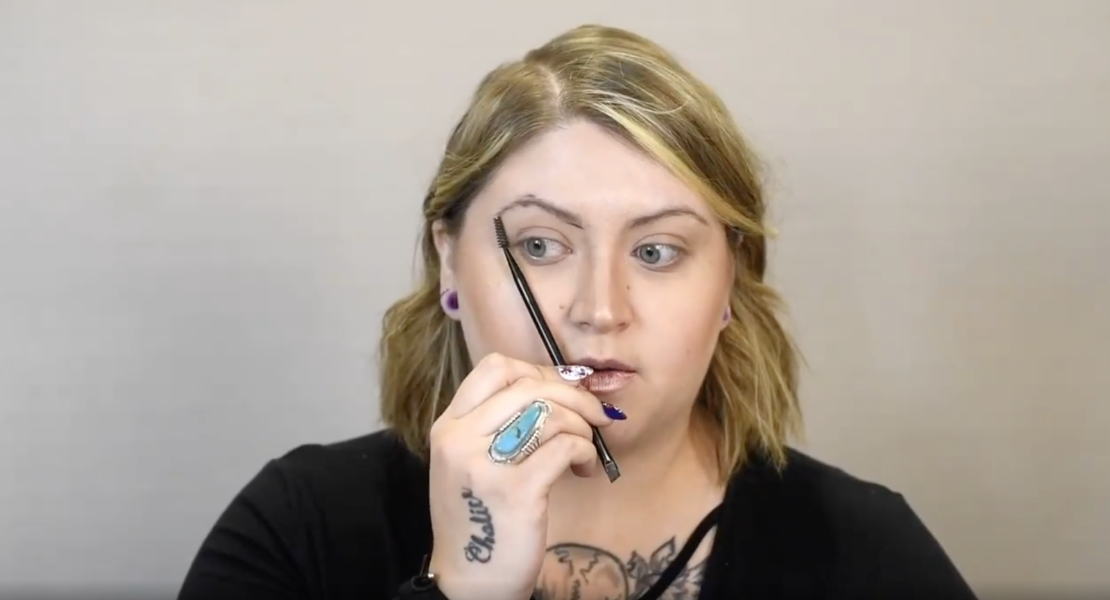 Instructor holding a makeup brush in front of face